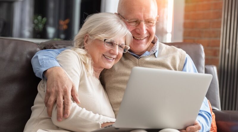 Senior couple browsing the internet together. Retirees using a laptop computer at home