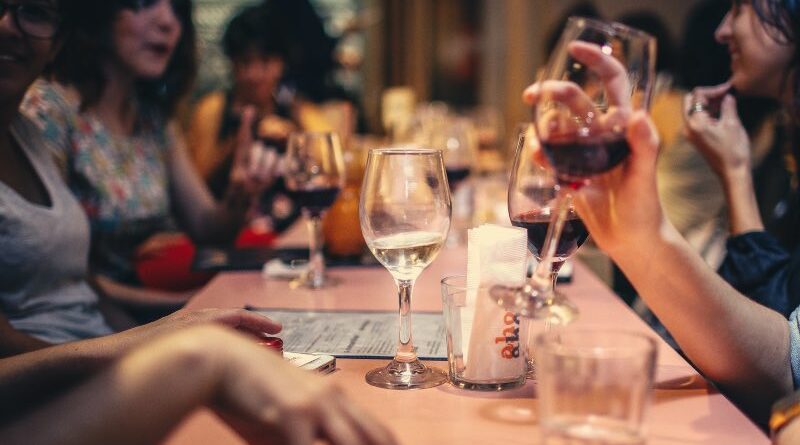 Diners at a restaurant table drinking wine