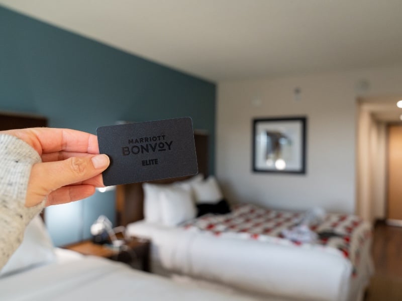 Hand holds a Marriott Bonvoy Key Card, black, for elite Ambassador status with the hotel chain
