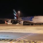 The Emirates A380 returns to Melbourne Airport in February 2022. Qantas planes in background