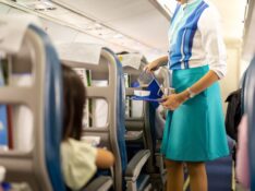 Flight attendant serving drinks to passengers on board
