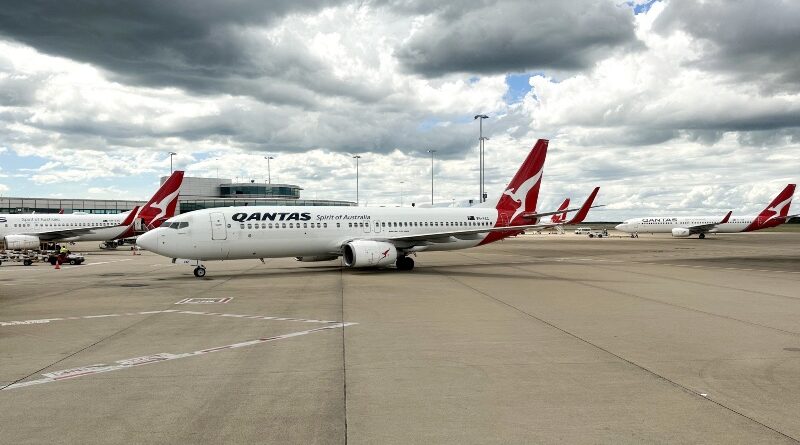 Qantas planes at Brisbane Airport under stormy clouds