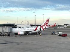 A Virgin Australia ex-KLM Boeing 737-700 at Brisbane Airport with Jetstar and Rex planes in background
