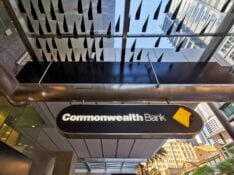 BRISBANE, AUSTRALIA - MAY 19, 2020: Banner of Commonwealth Bank of Australia (CBA) flagship headquarters office in Brisbane Central Business District on Queen Street. There are people standing on the street.