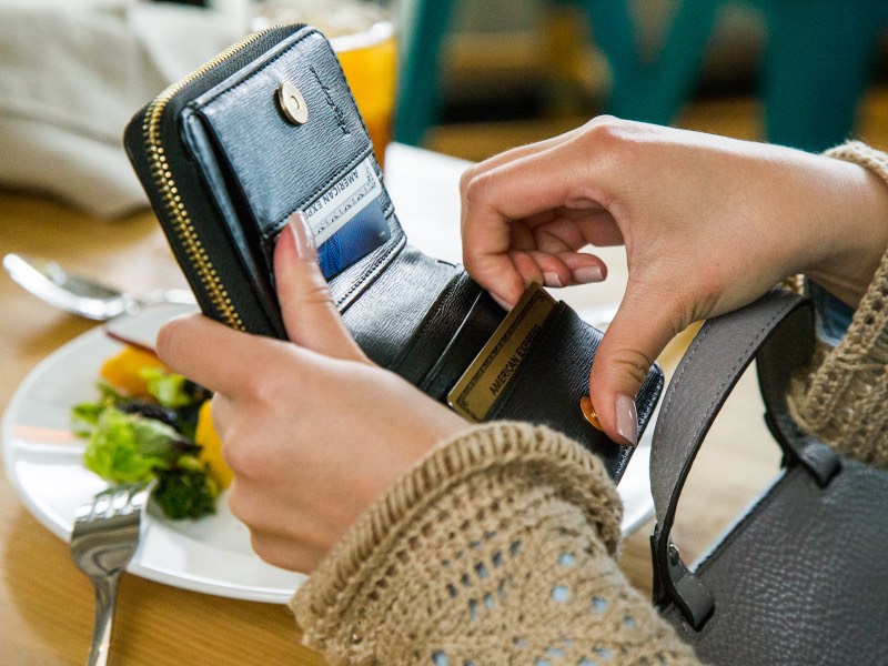 american express cards in wallet at restaurant