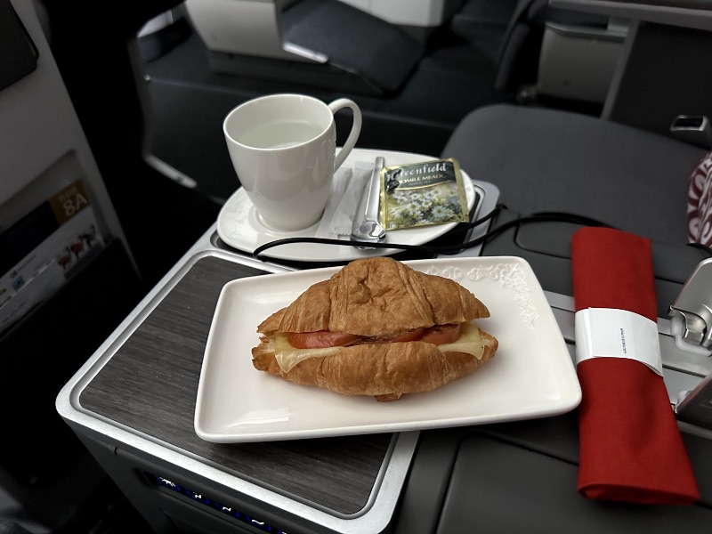 A warm cheese and tomato croissant was served as a pre-arrival snack