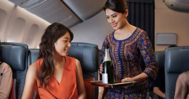 Singapore Airlines flight attendant offers champagne to premium economy passenger