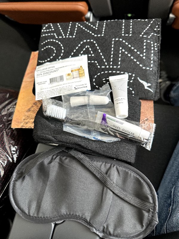 The Qantas amenity kit given in Premium Economy, including contents such as an eye mask, earplugs and cream.
