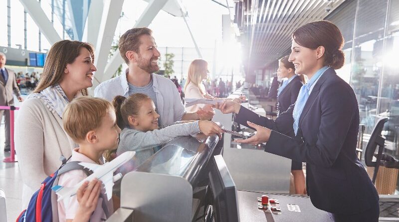 Family checking in at airport with boarding passes being handed over