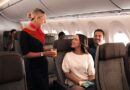 Qantas cabin crew giving orange juice to a couple on an Airbus A220 in economy