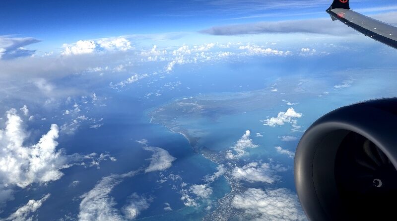 View of the wing flying over Caribbean islands on an Air Canada Boeing 737-8