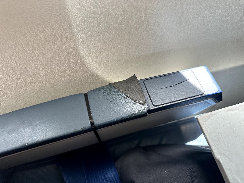 Airplane armrest tied up with a zip tie