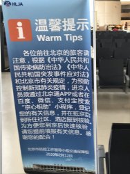 Sign at boarding gate informing passengers that registering with a Beijing health app is mandatory.