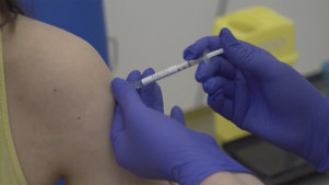 Screen grab taken from video issued by Britain's Oxford University, showing a person being injected as part of the first human trials in the UK to test a potential coronavirus vaccine, untaken by Oxford University in England. 