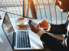Business traveller using phone computer coffee