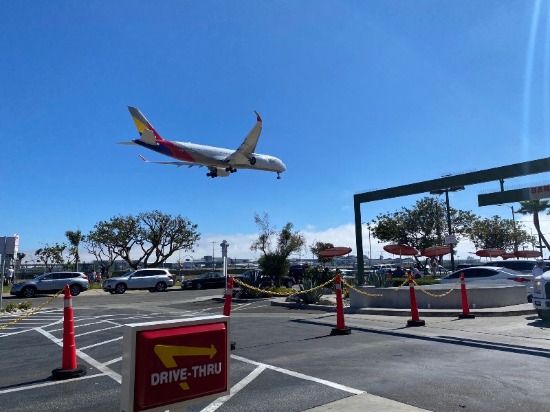 An Asiana A350 lands in Los Angeles as plane spotters look on from In-N-Out Burger